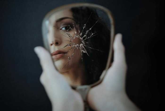 Woman sad, looking mirror after discovering hair loss