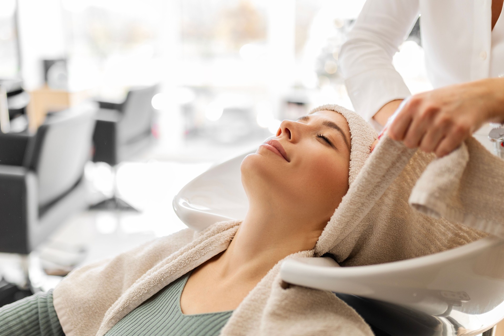 Young Woman Enjoys a Luxurious Hair Wash in Salon